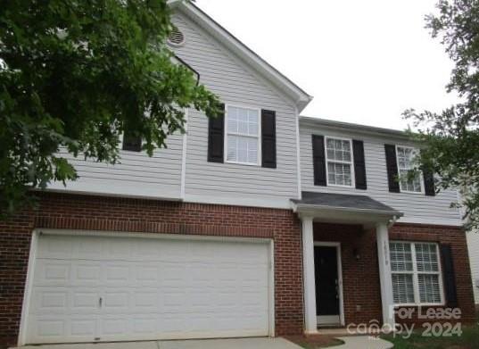 a front view of a house with a tree