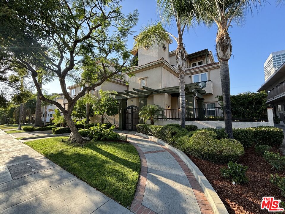 a front view of a house with garden and trees