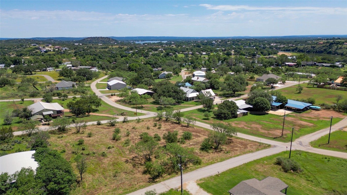 an aerial view of residential houses with outdoor space and trees