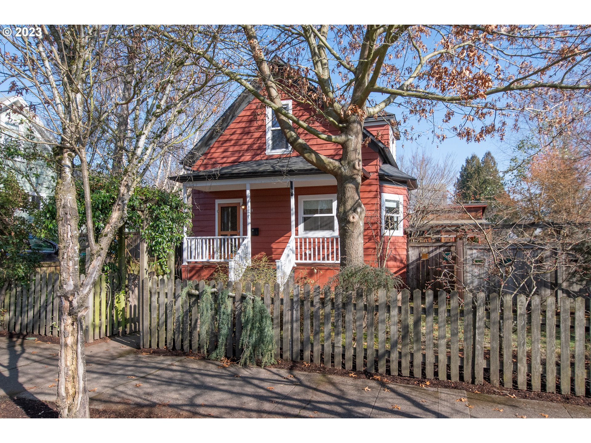 a view of house with a tree and front of it