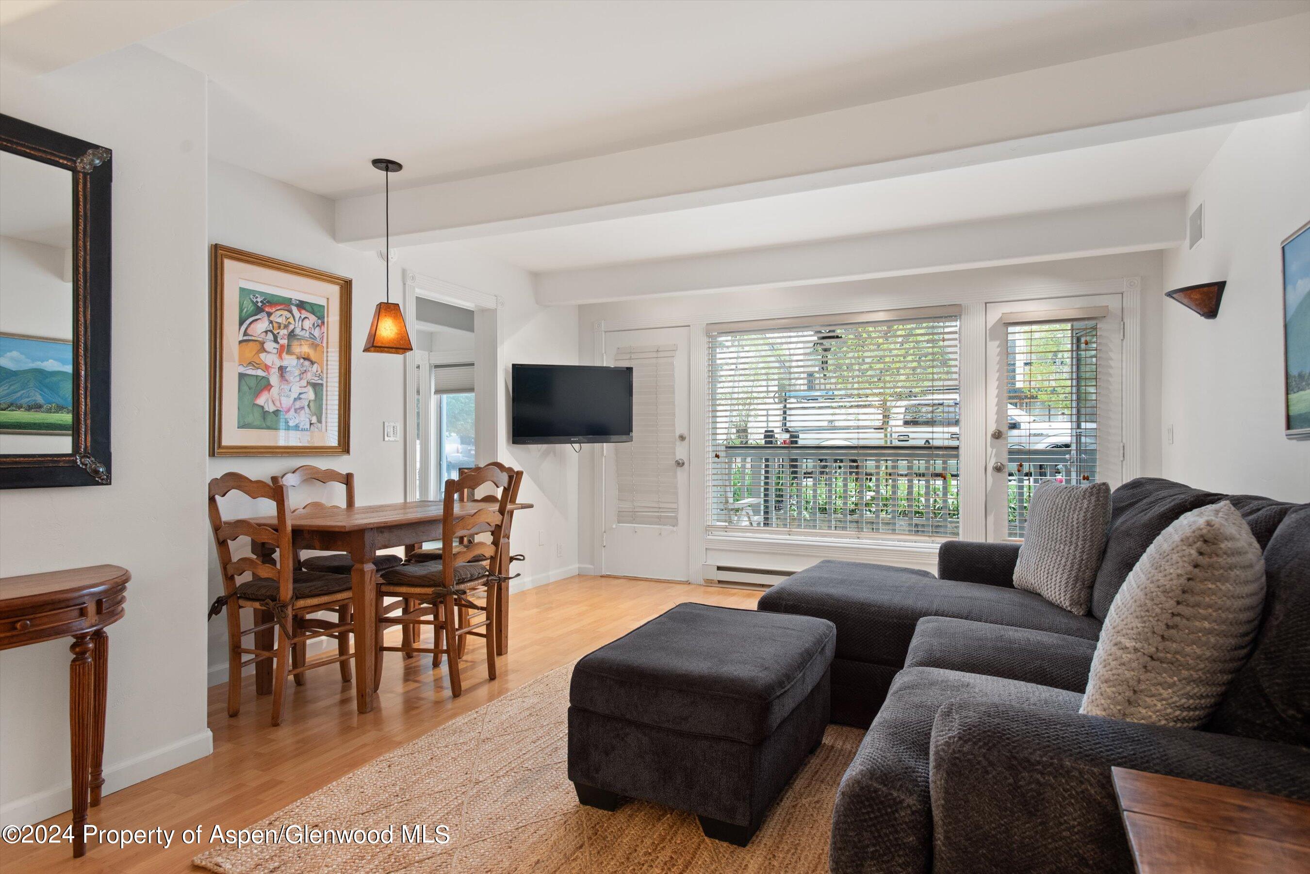 a living room with furniture floor to ceiling window and a flat screen tv