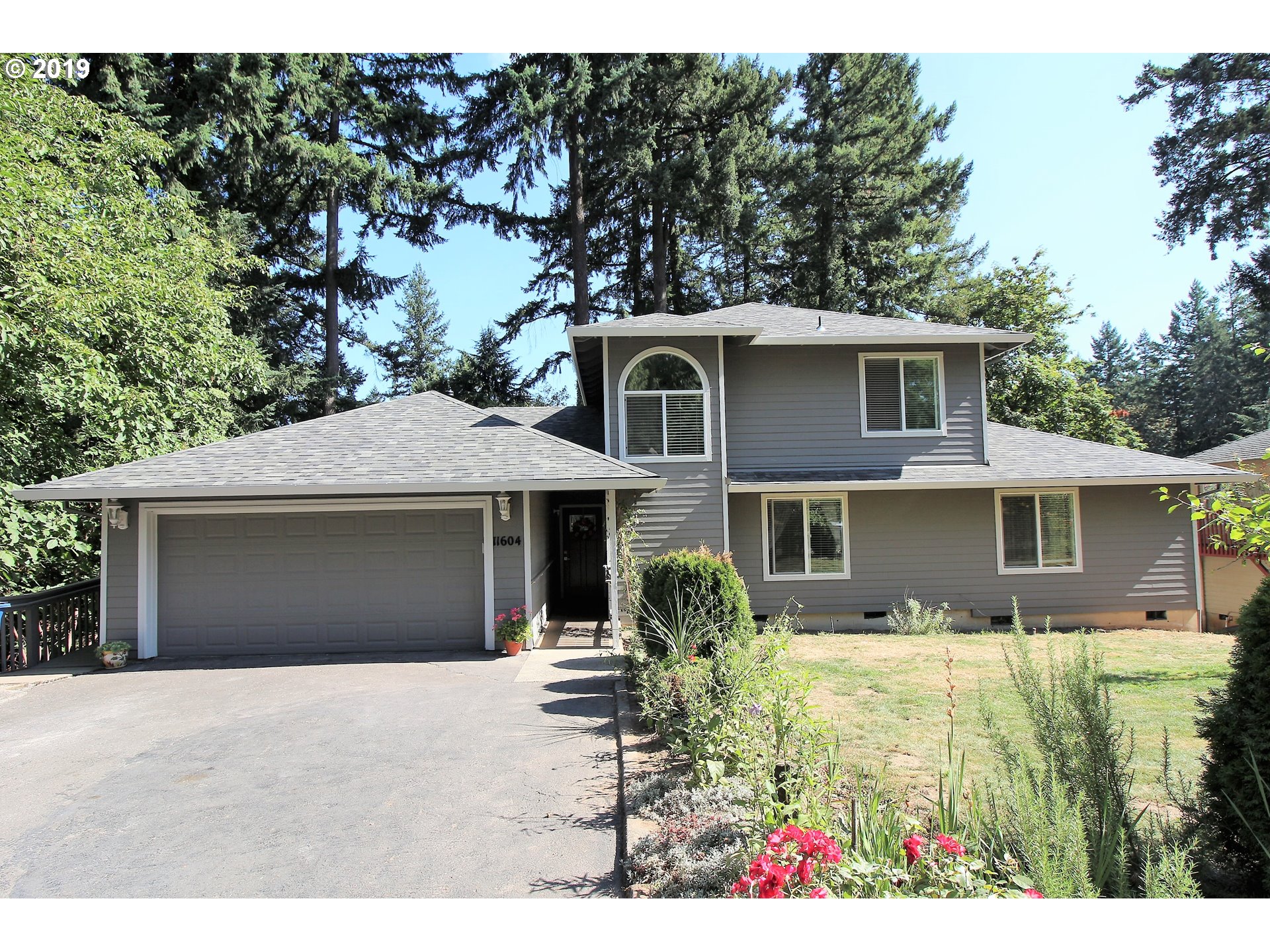 a front view of house with yard and trees around