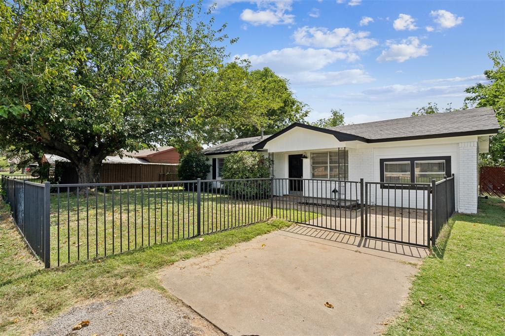 a view of house with a yard and a large tree