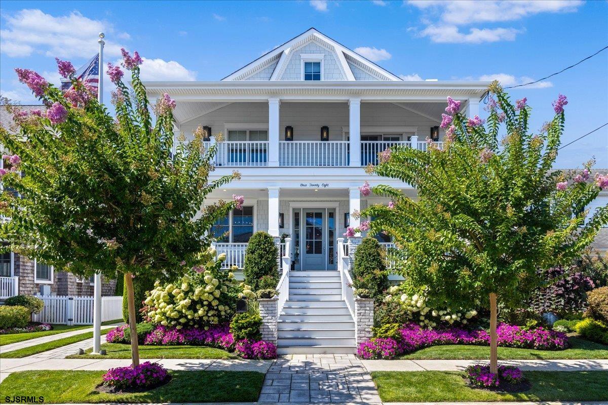 a front view of a house with a yard and potted plants