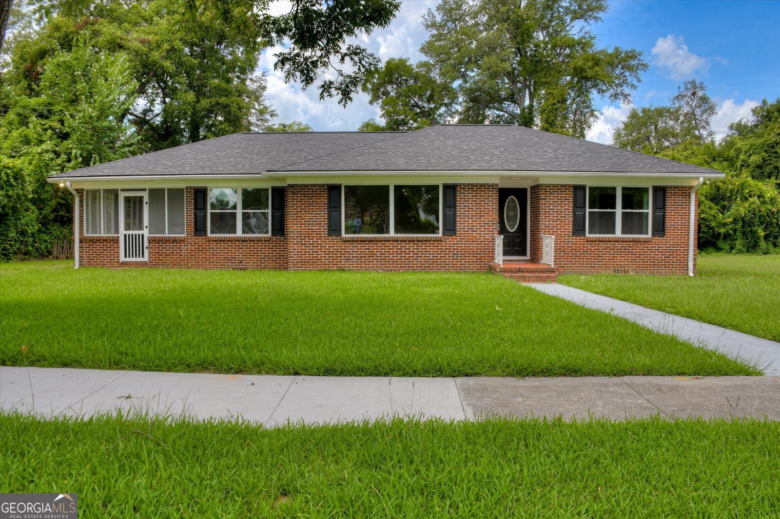 a front view of a house with a garden and yard