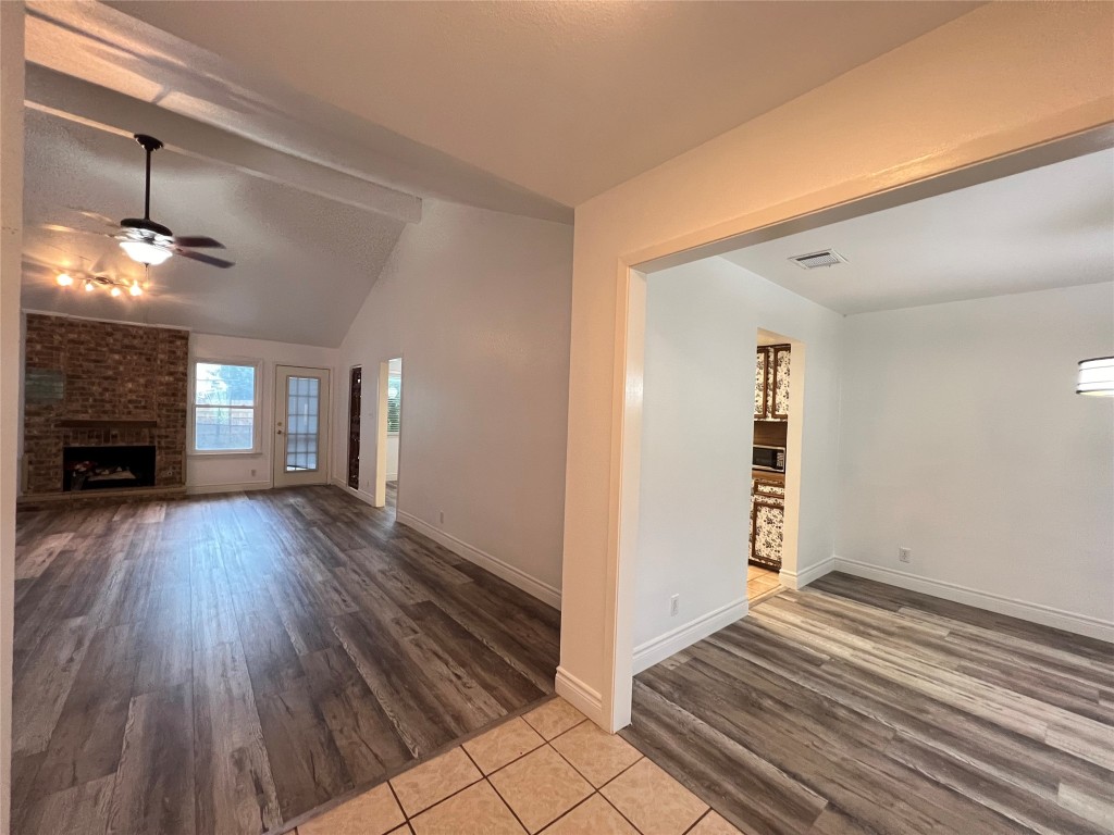 a view of a livingroom with wooden floor and a fireplace