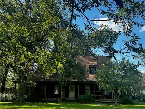 a view of a big house with a big yard and large trees