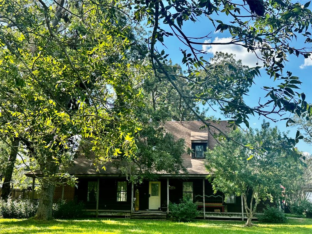 a view of a white house with a big yard and potted plants