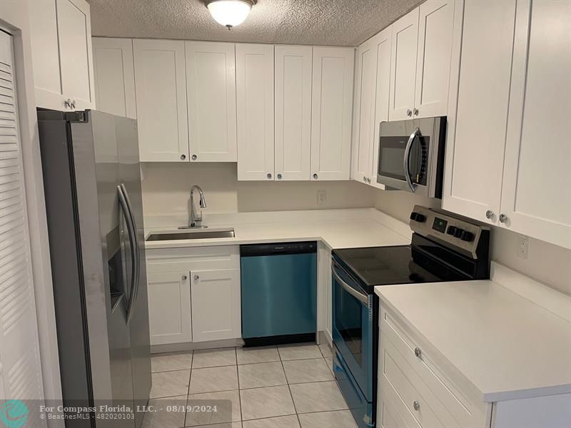 a kitchen with a sink stove and refrigerator