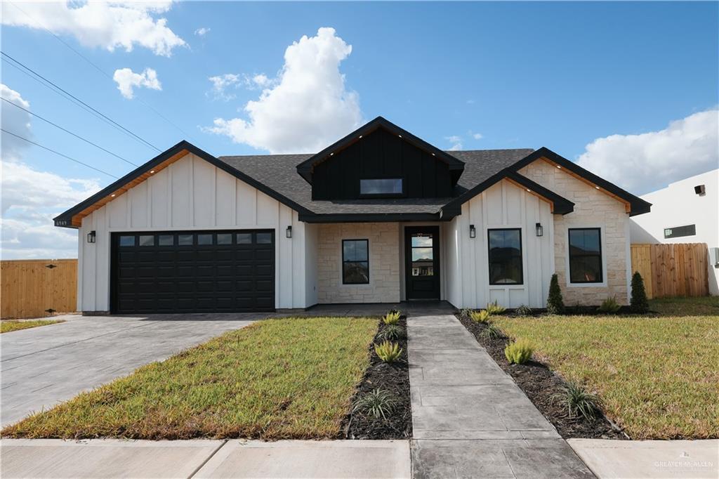 Modern farmhouse featuring a front yard and a garage