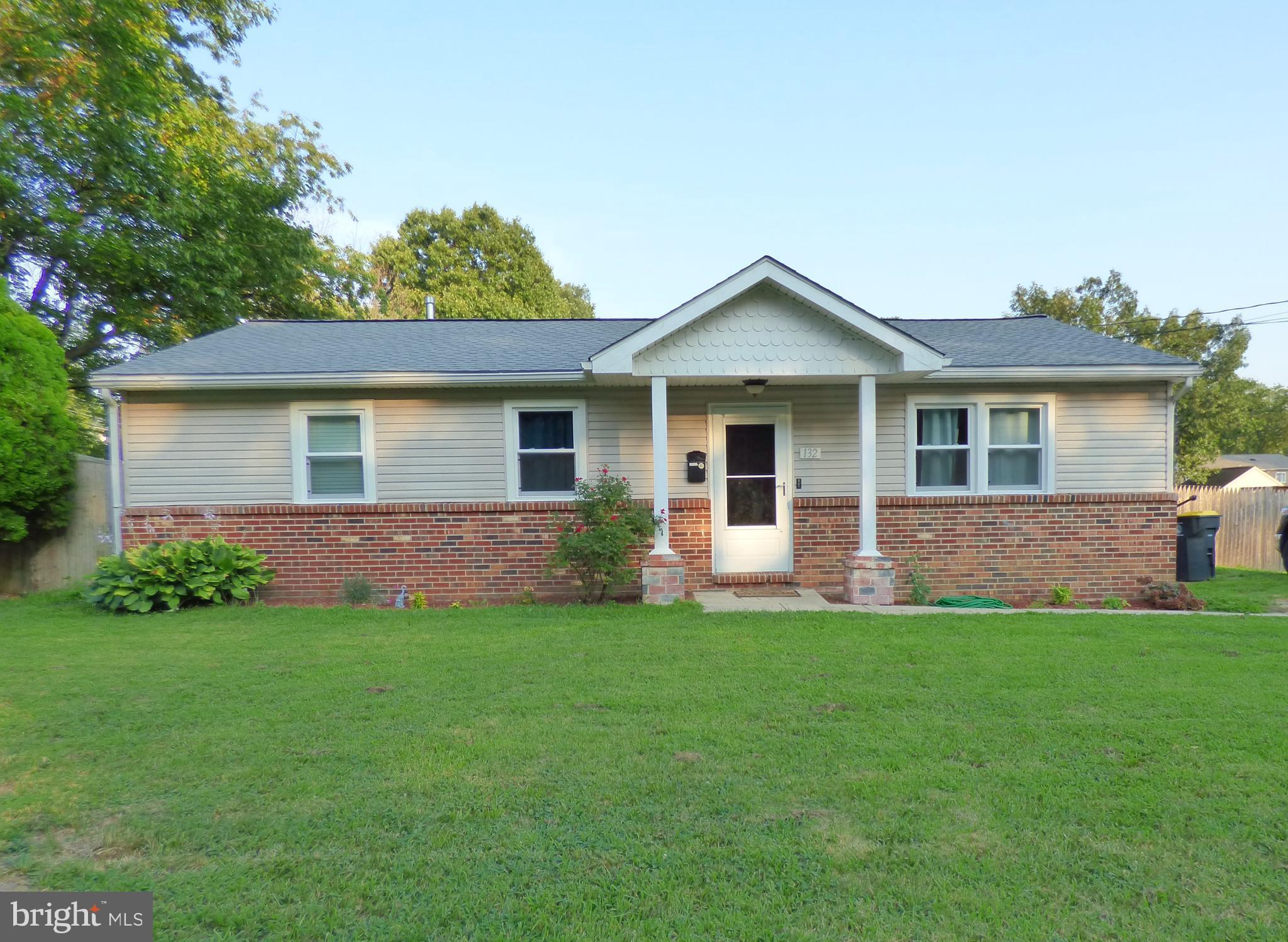 a front view of a house with a garden and yard