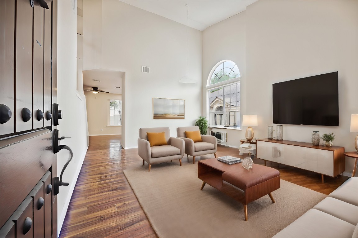 a living room with furniture a large window and a flat screen tv