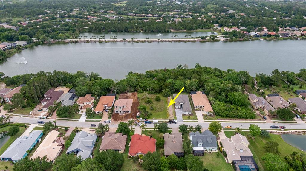 an aerial view of house with yard space and lake view