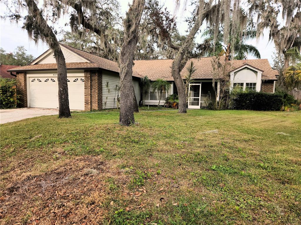 a front view of a house with a garden and trees