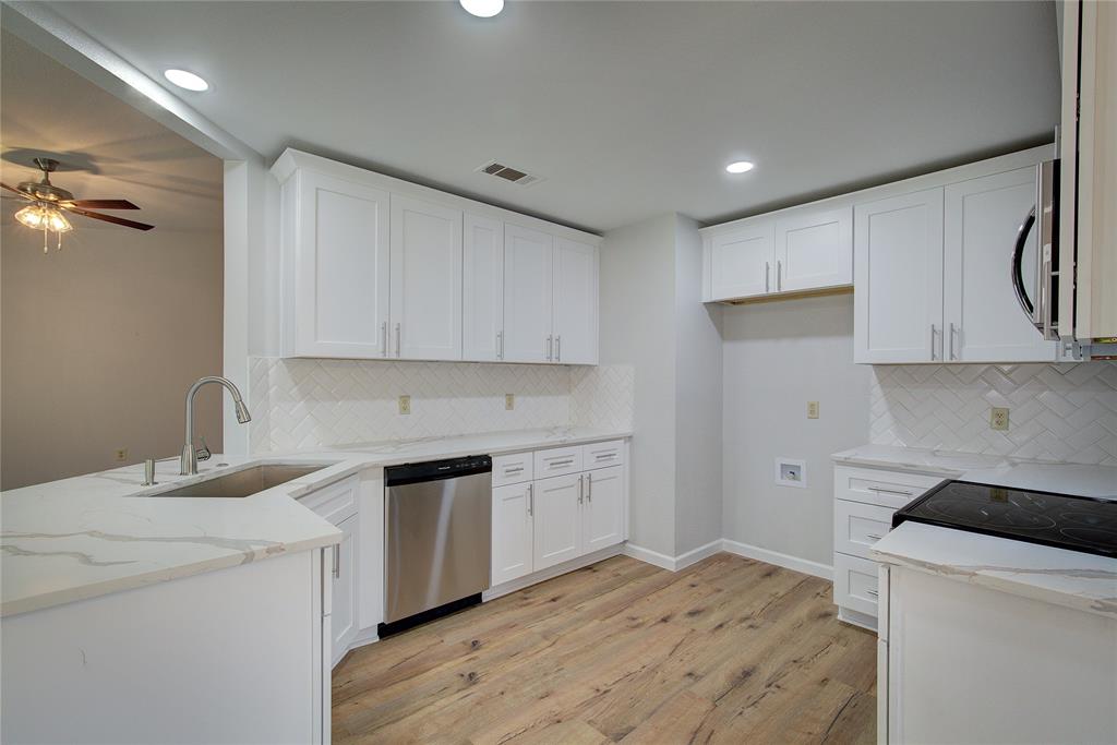 a kitchen with a sink a stove and cabinets