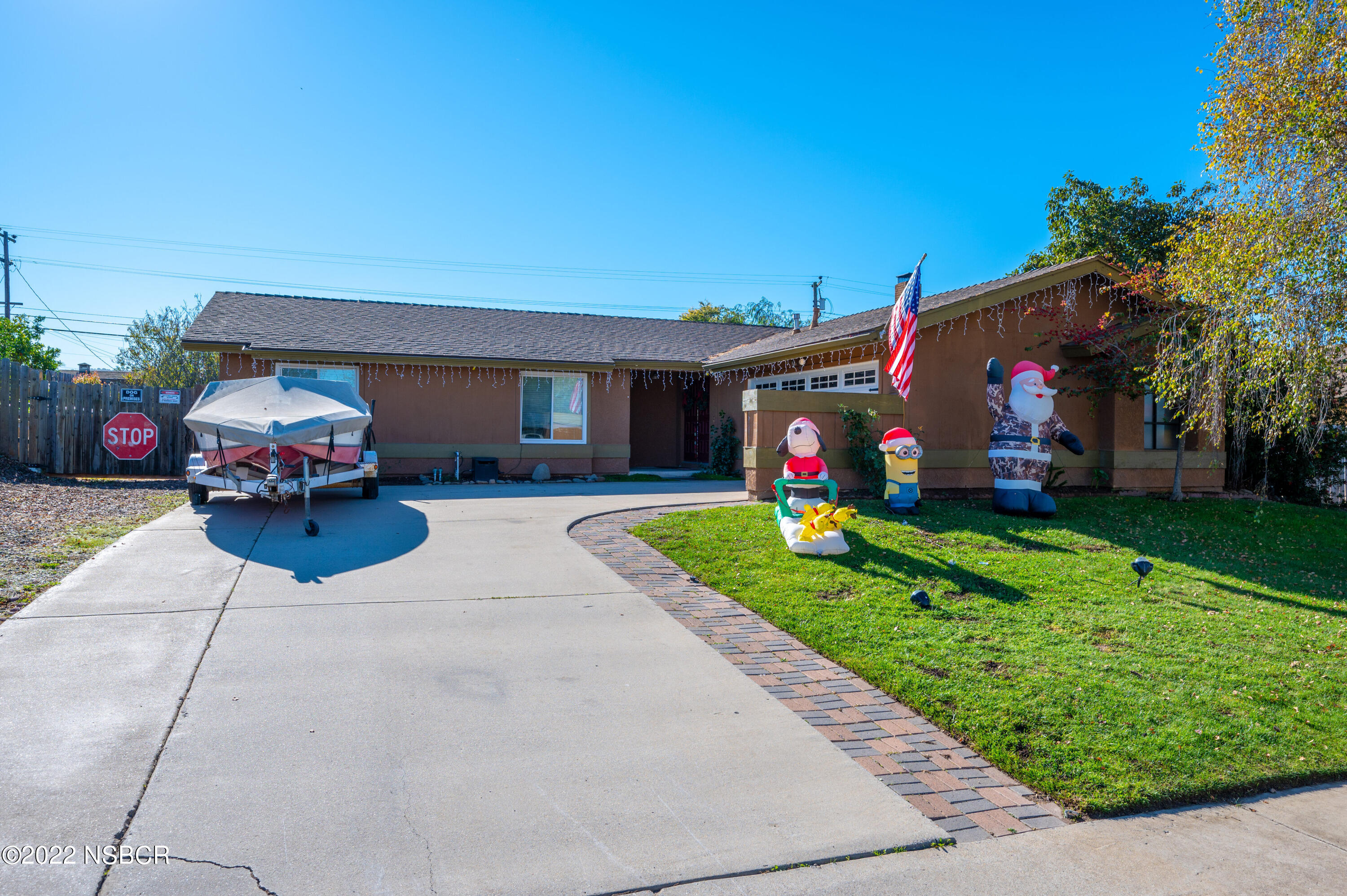 a front view of a house with a yard and potted plants