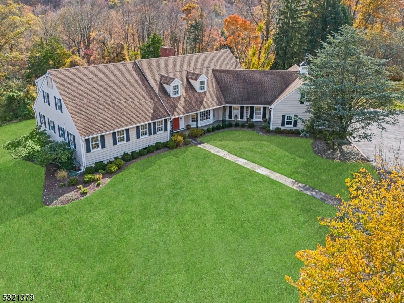 a aerial view of a house next to a big yard and large trees