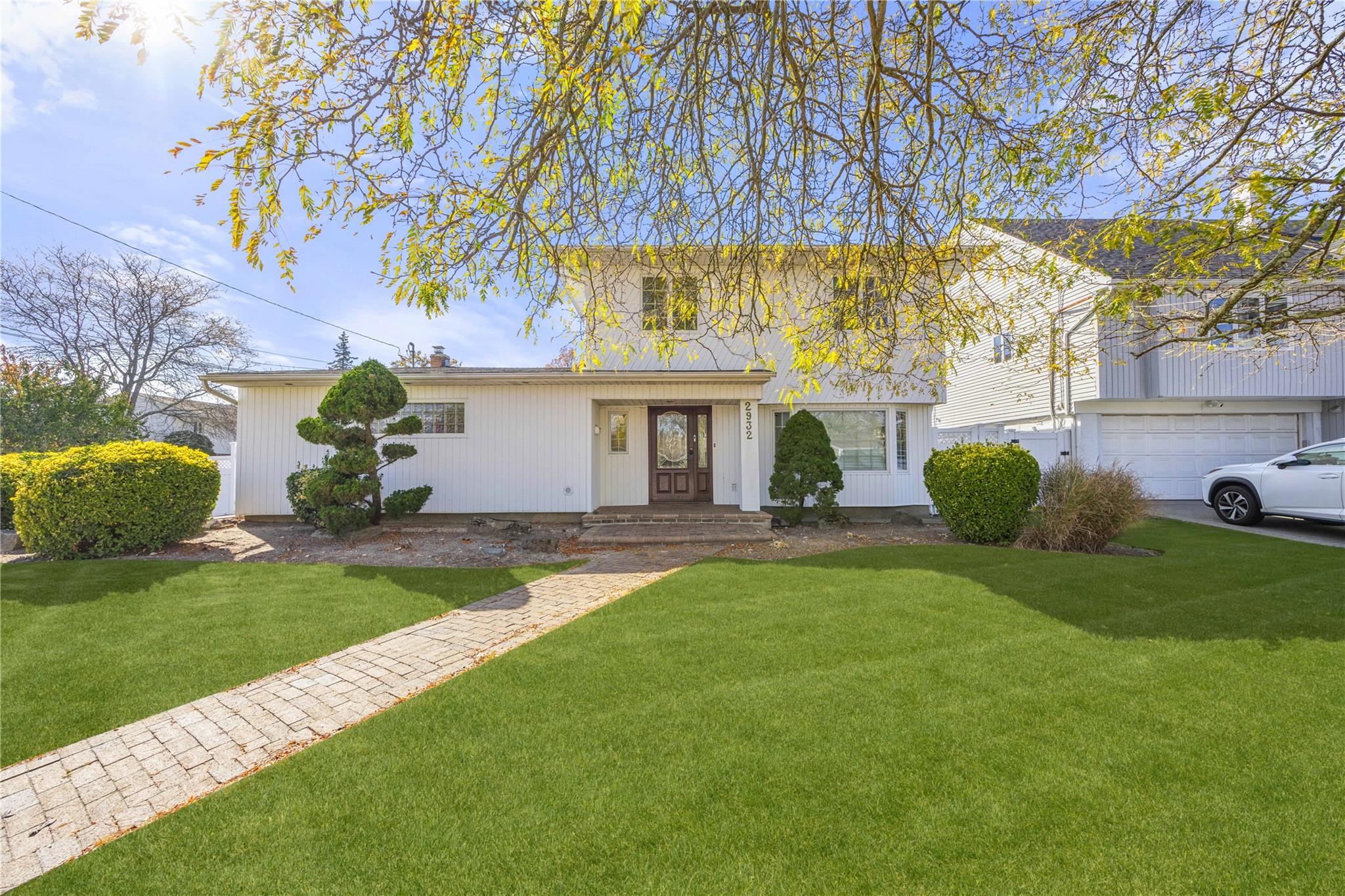 a view of an house with backyard and a tree