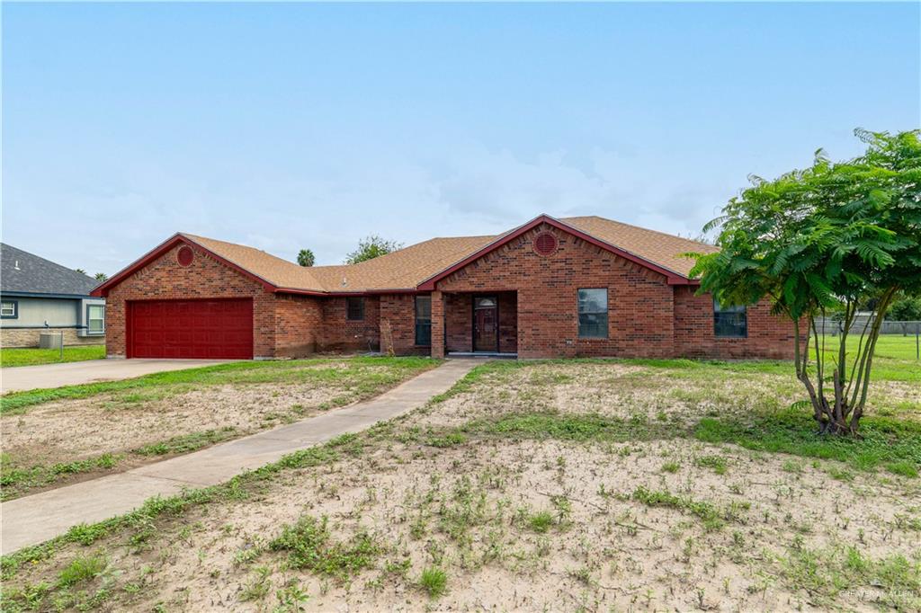 Ranch-style house with a front yard and a garage