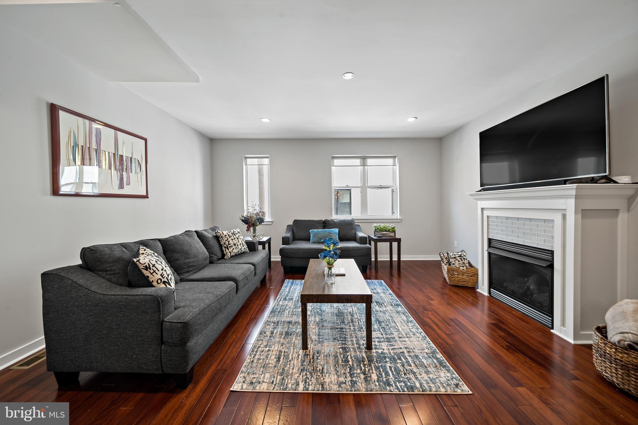 a living room with furniture a flat screen tv and a fireplace