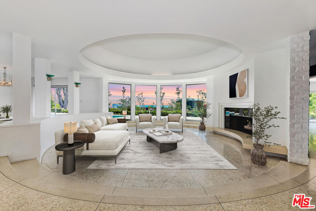 a living room with fireplace furniture and a large window