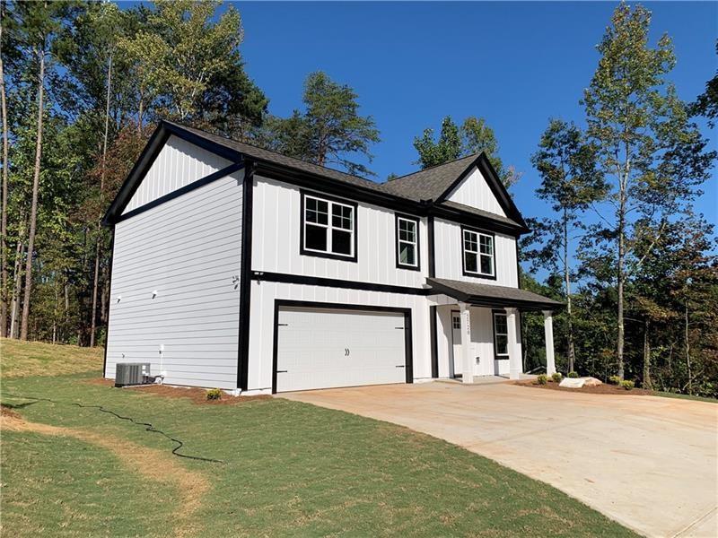 a front view of a house with a garden and garage