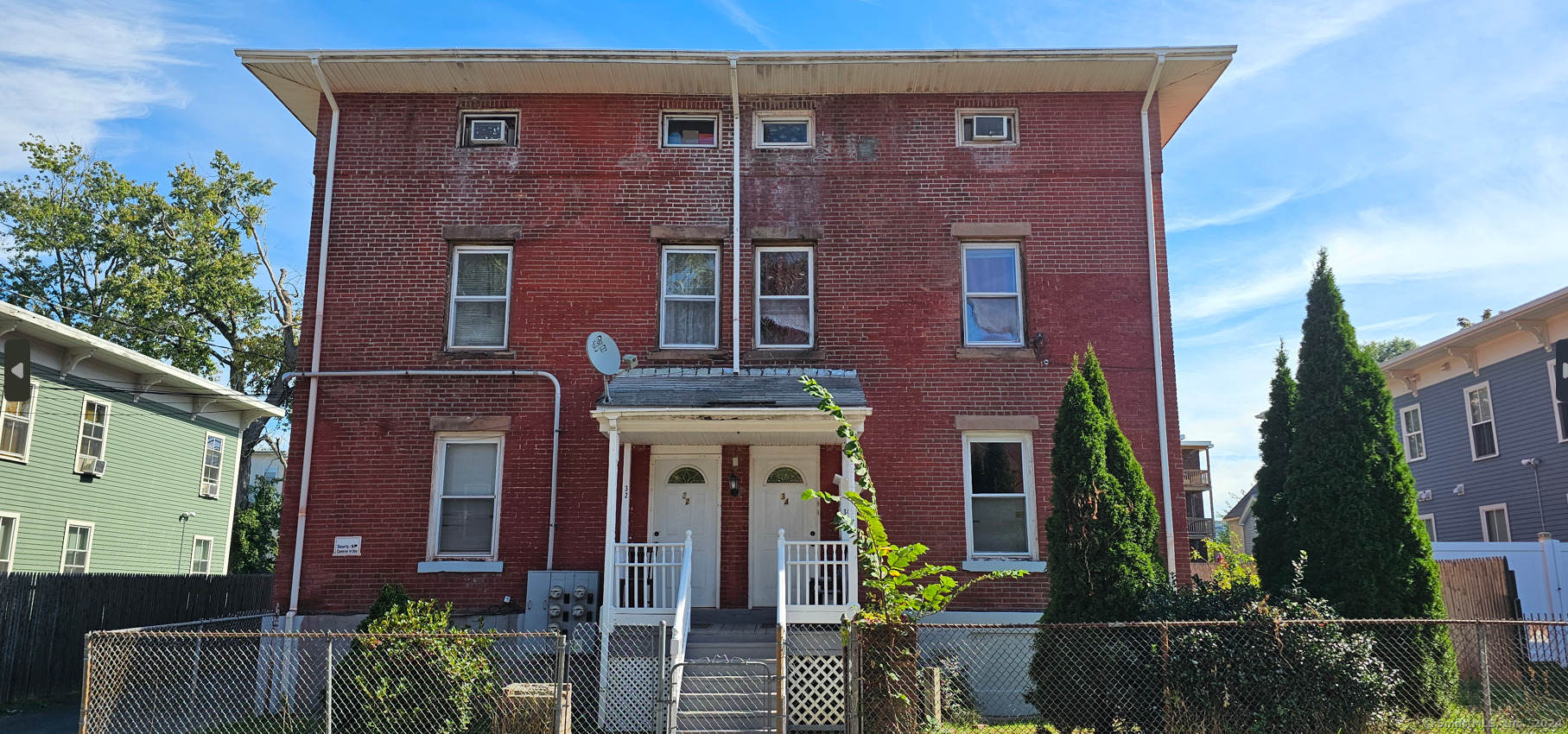 front view of a brick house with a small yard