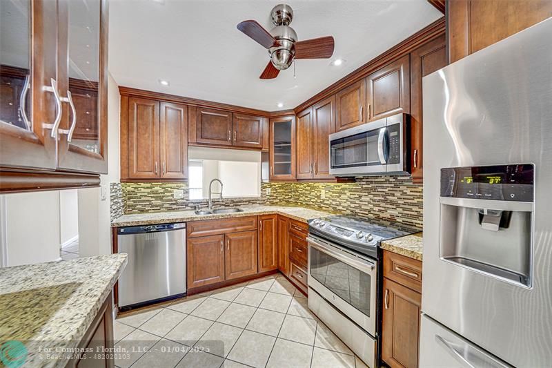 a kitchen with stainless steel appliances granite countertop a stove and a sink