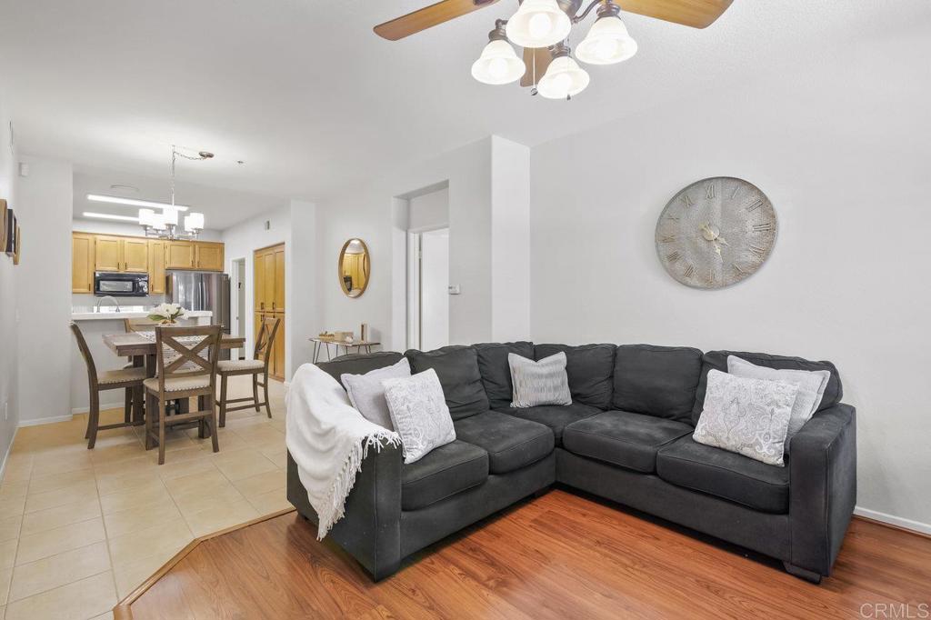 a living room with furniture kitchen view and a chandelier