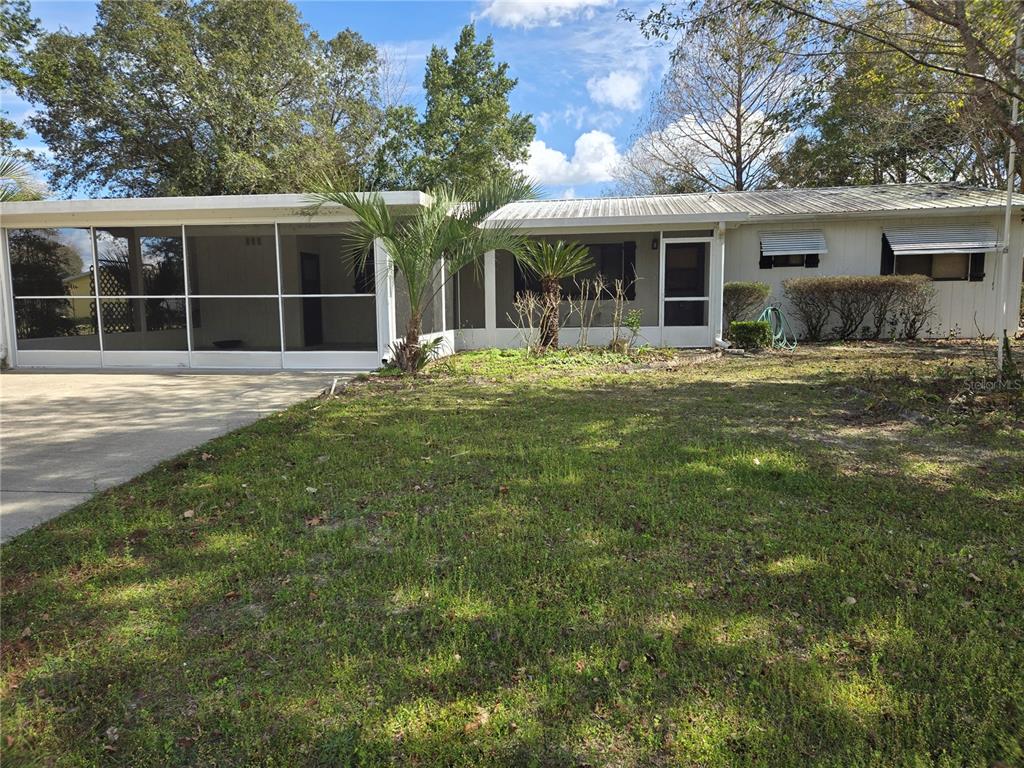 a view of a house with a yard and sitting area