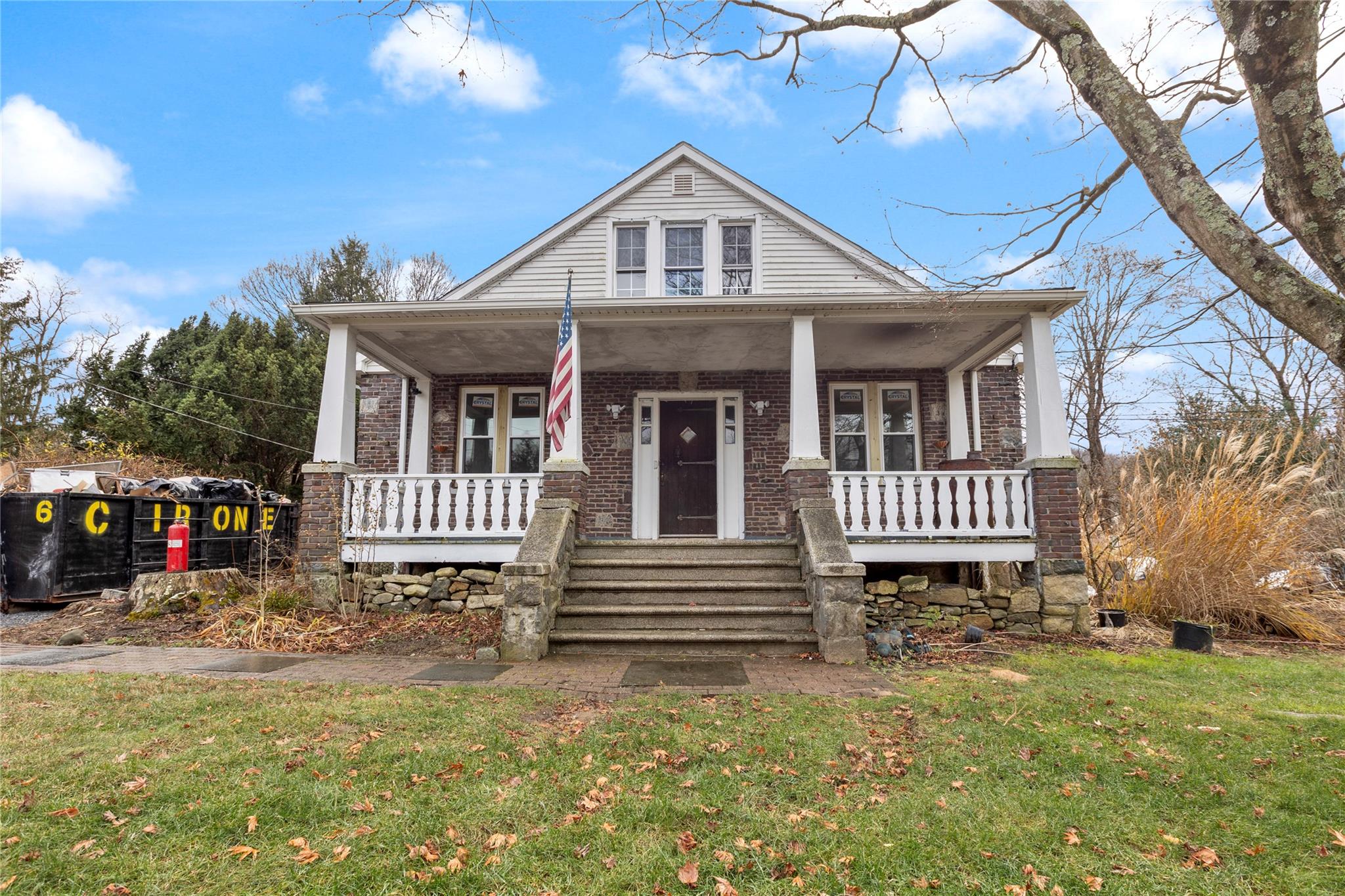 View of front of property with a porch and a front lawn