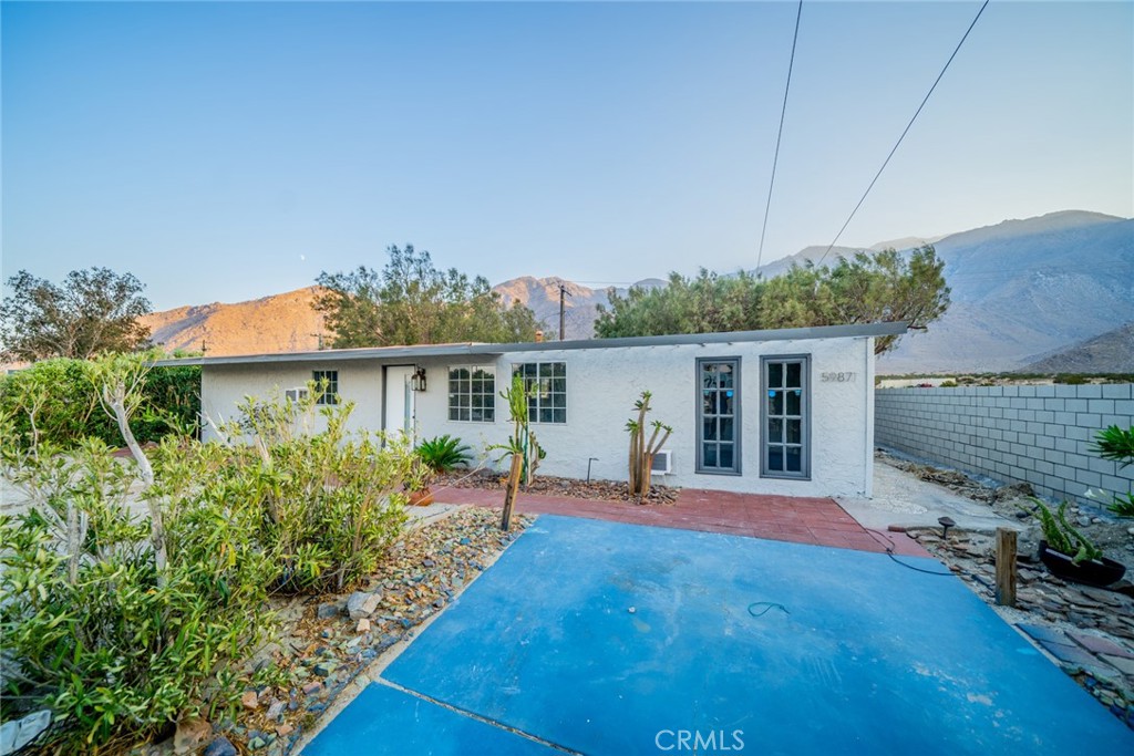 a front view of a house with a yard and potted plants