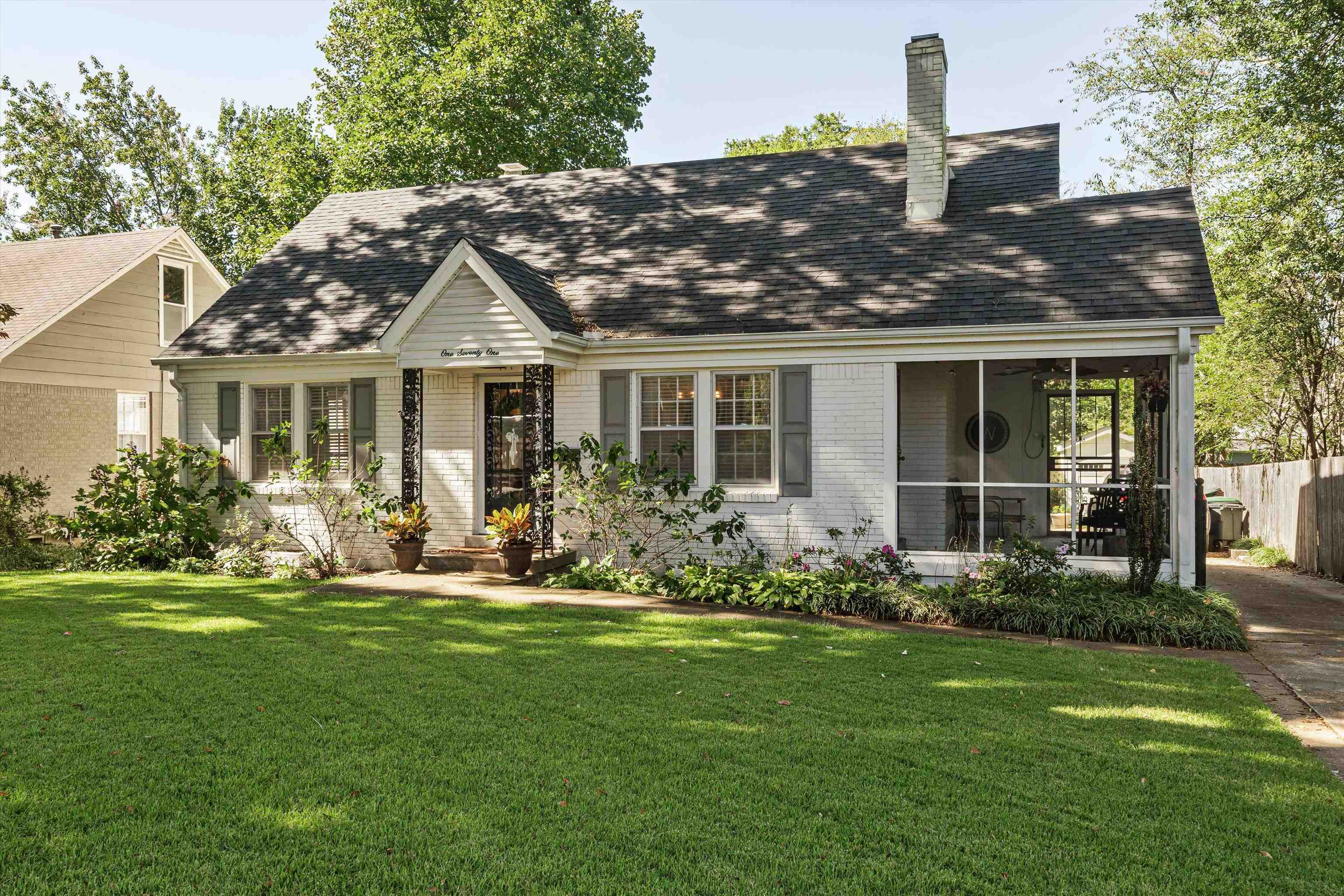 a front view of a house with a garden and plants