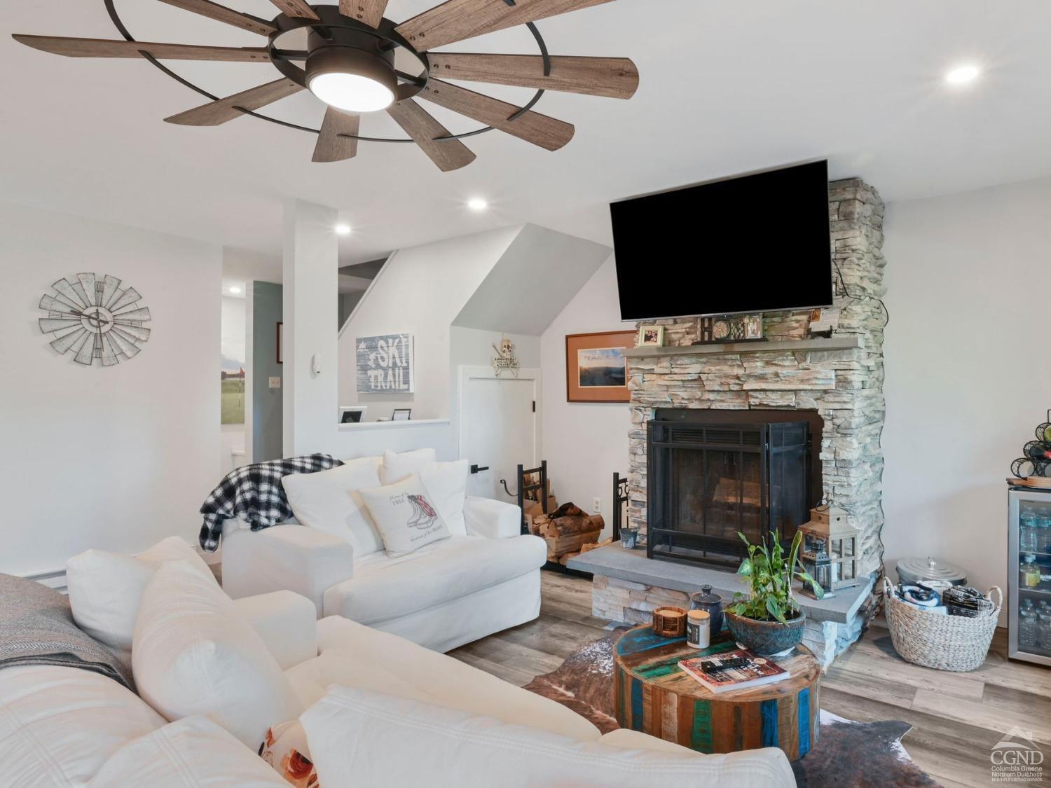 a living room with furniture a flat screen tv and a fireplace