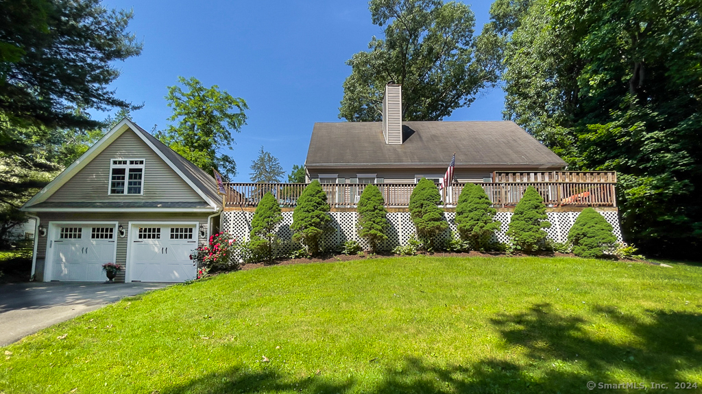 a view of house with garden and tall trees