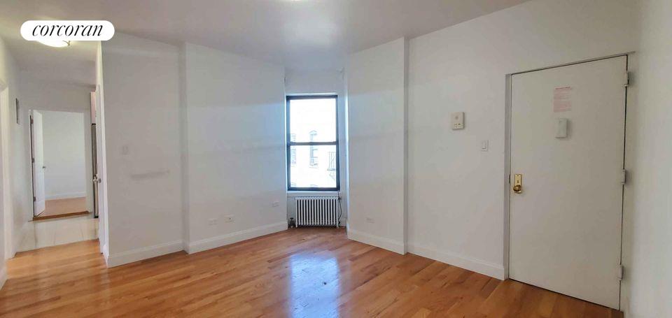 an empty room with wooden floor and a window