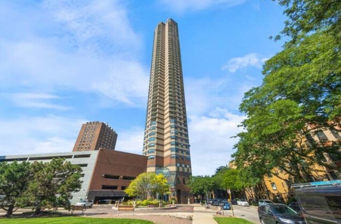 a view of a tall building next to a yard