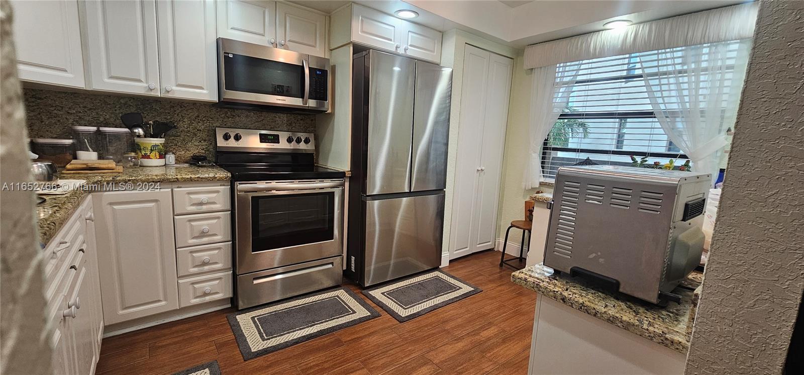 a kitchen with stainless steel appliances a stove a sink and a refrigerator