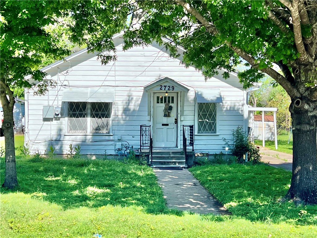 a front view of a house with a yard and fence