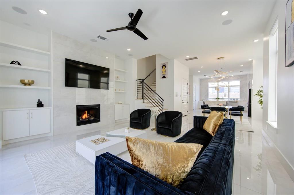 a living room with furniture a flat screen tv and a fireplace