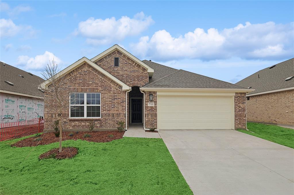 Single story home featuring a garage, brick siding, concrete driveway, roof with shingles, and a front yard