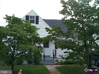 a front view of a house with a yard and tree