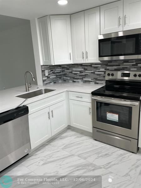 a kitchen with cabinets stainless steel appliances and a sink