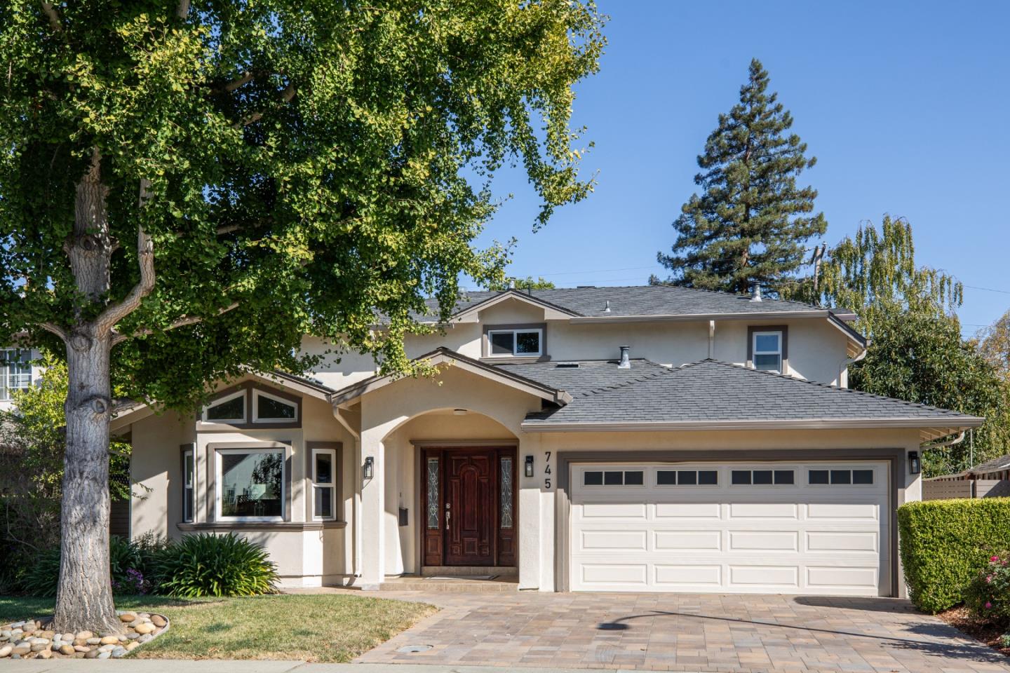 a front view of a house with a tree