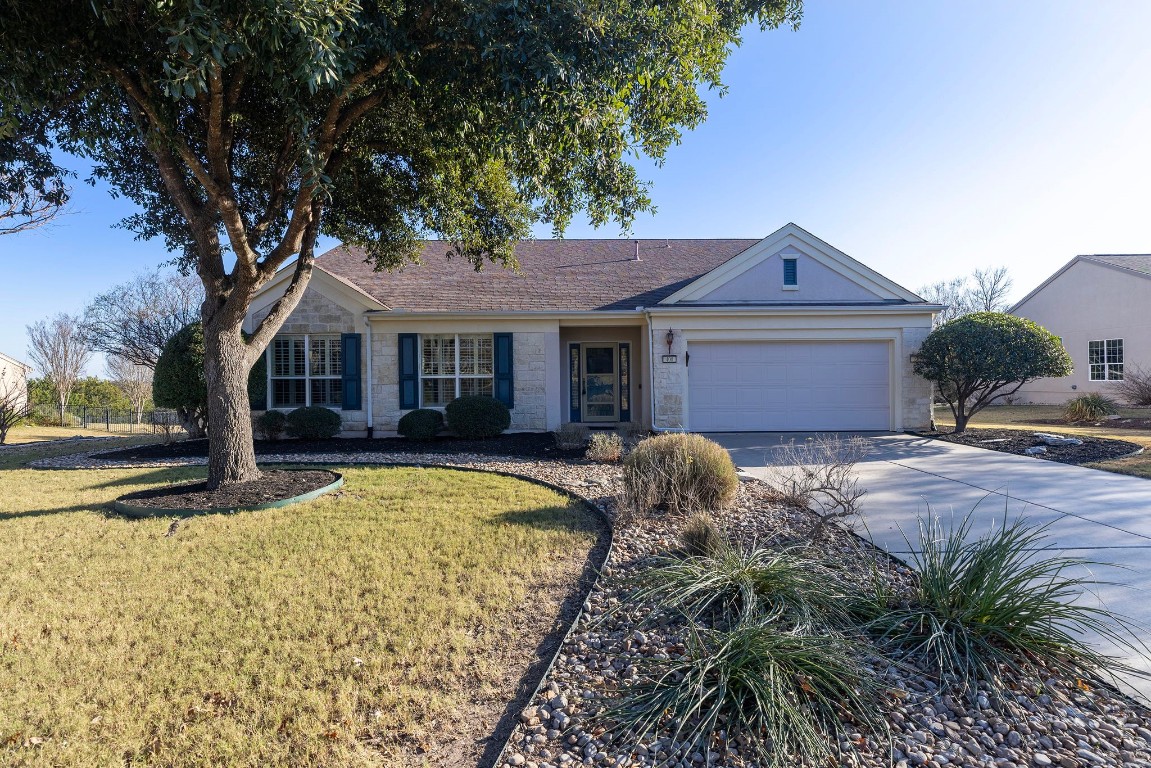 a front view of a house with a garden and yard