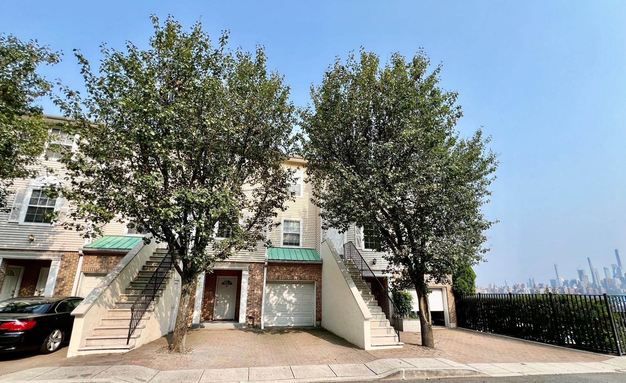 a front view of a house with a tree