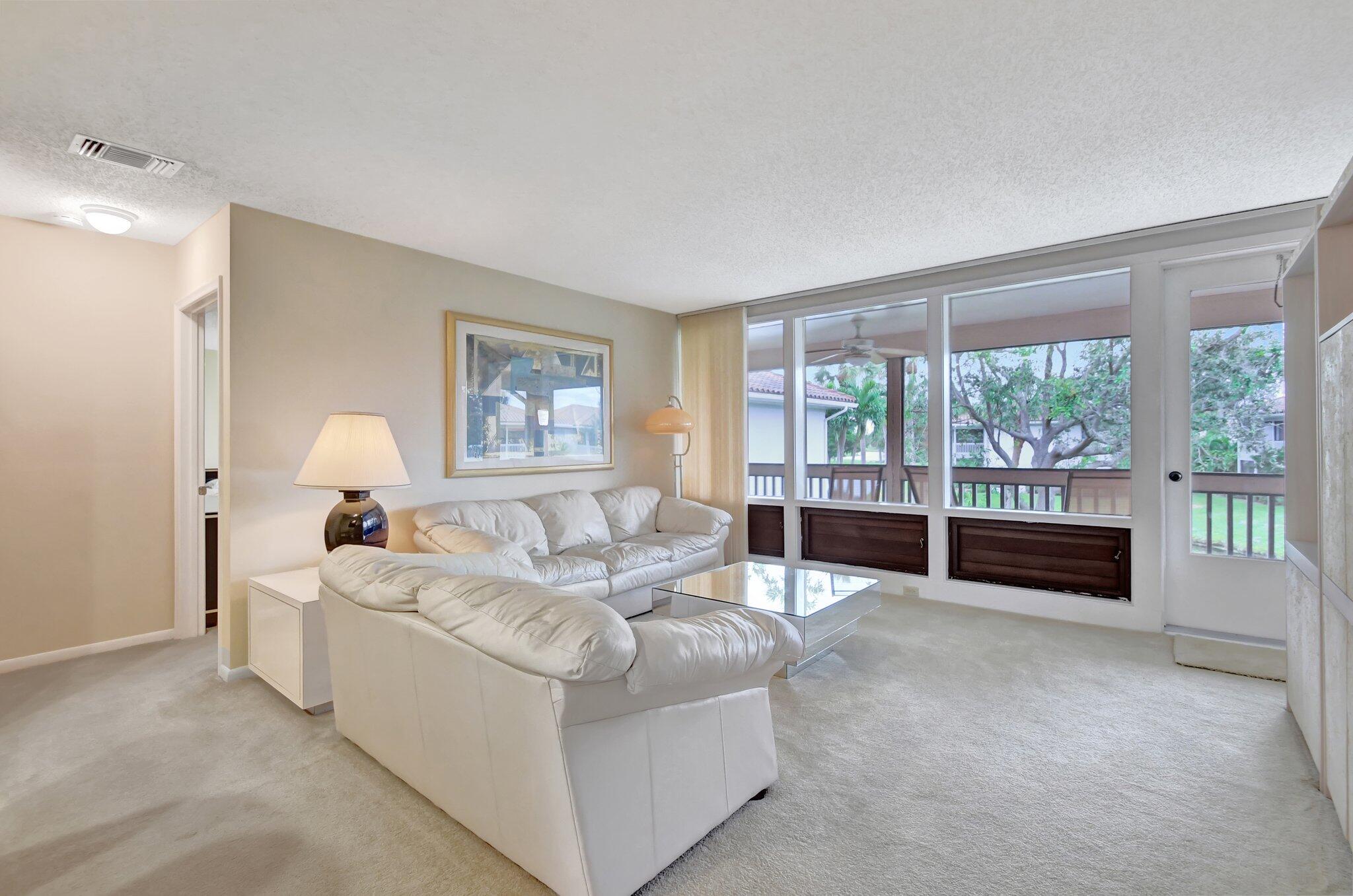 a living room with furniture and large windows