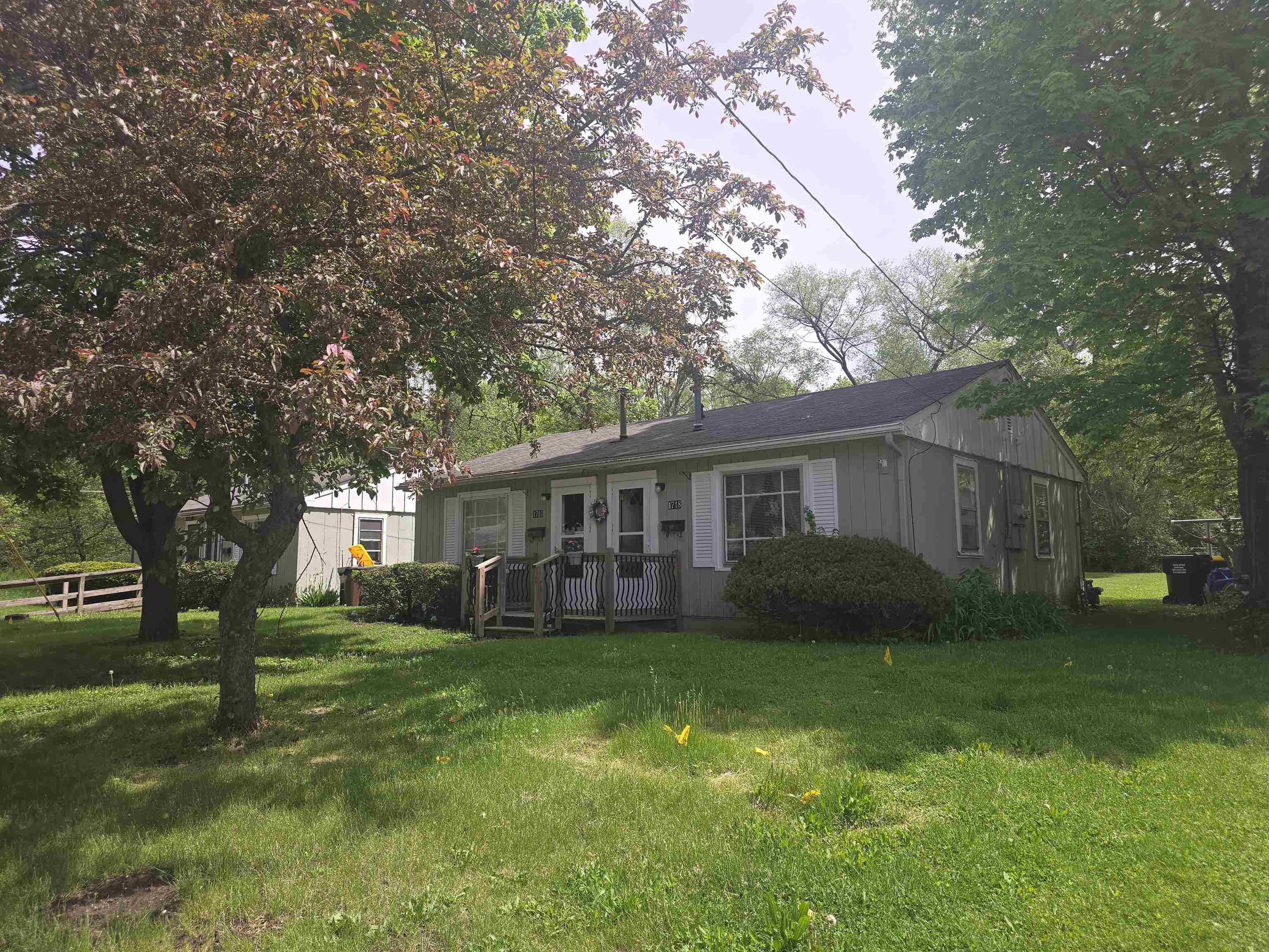 a view of a house with a big yard and large trees