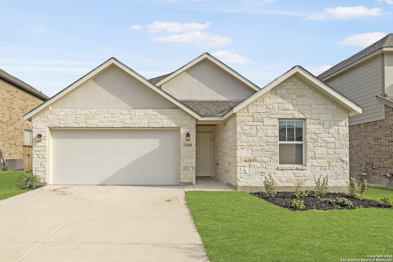 a front view of a house with a yard and garage