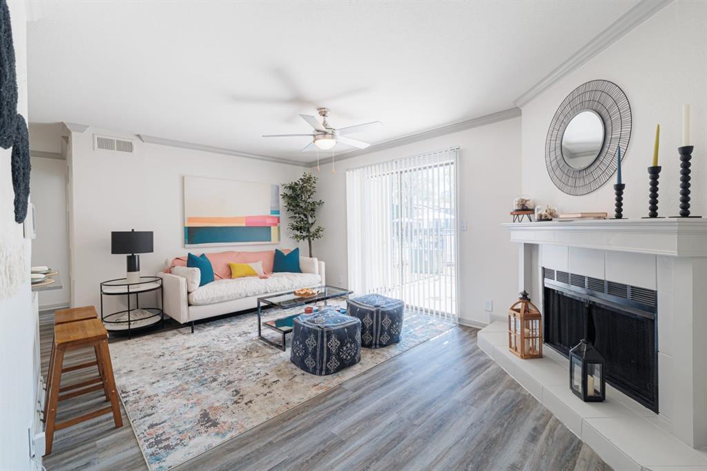 a living room with furniture a fireplace a flat screen tv and window